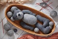 Knitted details of a toy teddy bear lying in a wicker basket Royalty Free Stock Photo