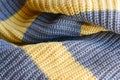 Knitted fabric large knitted yellow with grey stripes horizontally.