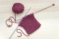 Knitted fabric, wool red ball and knitting needles Royalty Free Stock Photo