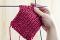 Knitted fabric, wool red ball and knitting needles Royalty Free Stock Photo