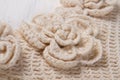 Knitted flower on beige cloth.