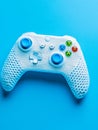 Knitted game controller with colorful buttons on vibrant blue background. Royalty Free Stock Photo
