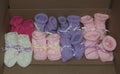 Knitted Girl Baby Booties with Ribbons Lined Up in a Row - Colors: Pink, Purple, White