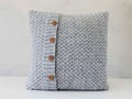 Knitted grey pillow with wooden buttons Royalty Free Stock Photo