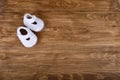 Knitted handmade baby shoes on wood background