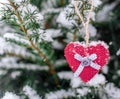 Knitted heart hanging on a branch. Symbol of love and Valentine`s day celebration. Lonely heart