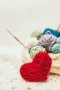 Knitted heart symbol and balls of yarn