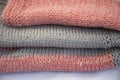 Knitted items are stacked. Pink jersey with gray stripes. Knitted fabric