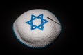 Knitted kippah with blue David star on black background close up. Seder concept