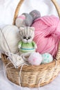 A knitted kitten with knitting needles, colored balls of thread in a basket. Royalty Free Stock Photo