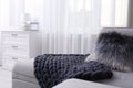 Knitted merino wool blanket on sofa in room. Interior design Royalty Free Stock Photo