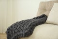 Knitted merino wool plaid on sofa in room Royalty Free Stock Photo