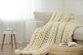 Knitted merino wool plaid on sofa in room Royalty Free Stock Photo