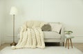 Knitted merino wool plaid on sofa in room Royalty Free Stock Photo