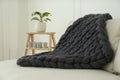 Knitted merino wool plaid on sofa in room Royalty Free Stock Photo