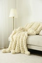 Knitted merino wool plaid on sofa in room Royalty Free Stock Photo