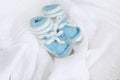 Knitted newborn baby booties on crocheted blanket white background Royalty Free Stock Photo