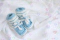 Knitted newborn baby booties on crocheted blanket white background with colorful hearts Royalty Free Stock Photo