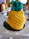A knitted pineapple is used as a tea warmer for a teapot Royalty Free Stock Photo