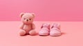 Knitted pink blue booties and toy bear on a pink background