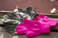 Knitted pink gloves and dark green autumn leaf of a poplar Royalty Free Stock Photo