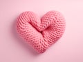 Knitted pink heart on a pink background with copy space