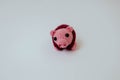Knitted pink pig with crimson vest on white background, mini pig, handmade, toys