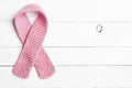 Knitted Pink Womens Breast Cancer Symbol laying flat on Rustic White Wood Board Background with room or space for copy, text, or y