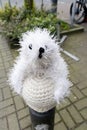 Knitted and stuffed polar bear atop a pole outdoors