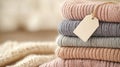 knitted sweaters in stack with tag,stack of folded soft fashionable sweaters in pastel colors with empty tag, sale of sweaters in Royalty Free Stock Photo