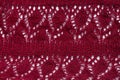 Knitted texture burgundy fabric background. Dark red cloth on light surface for design. Handmade backdrop material