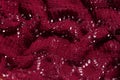 Knitted texture burgundy fabric background. Dark red cloth on light surface for design. Handmade backdrop material