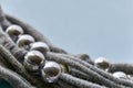 Knitted threads with silver coloured beads against blue