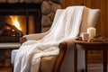 a knitted throw draped over a comfortable chair near a spa fireplace