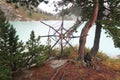 Knitted tibetan mandala from threads and yarn. Mountain lake on the background. Hand crafted and esoteric dream catcher, sacred