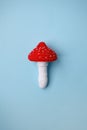 Knitted toy amanita on blue background. Earlier tactile development of children, craft toys, poisonous food.