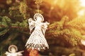 Knitted toy angel on a fir tree in sunlight. Christmas concept. Closeup Royalty Free Stock Photo