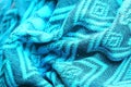 Knitted turquoise-coloured fabric with soft folds and with a geometric drawing view from the top in light from the window. Royalty Free Stock Photo