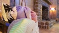 Knitted and warm blankets are folded and laid in a wicker basket near the fireplace. Cozy interior in the house. Details of a