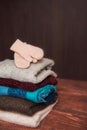 Knitted, winter sweaters and warm mittens on a wooden background.