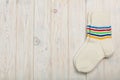 Knitted wool socks white color on bright wooden background. Royalty Free Stock Photo