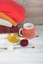 Knitted wool sweaters. Pile of knitted winter, autumn clothes on red, wooden background, sweaters, knitwear, ball, cup Royalty Free Stock Photo