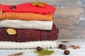 Knitted wool sweaters. Pile of knitted winter, autumn clothes on red, wooden background, sweaters, knitwear, leaf space for text. Royalty Free Stock Photo