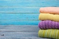 Knitted wool sweaters. Pile of knitted summer clothes on wooden background, sweaters, knitwear, space for text Royalty Free Stock Photo