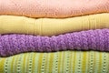 Knitted wool sweaters. Pile of knitted summer clothes on wooden background, sweaters, knitwear, space for text Royalty Free Stock Photo