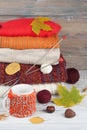 Knitted wool sweaters. Pile of knitted winter, autumn clothes on red, wooden background, sweaters, knitwear, ball, cup Royalty Free Stock Photo