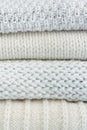 Knitted wool sweaters. Pile of knitted winter clothes on wooden background, sweaters, knitwear, space for text Royalty Free Stock Photo