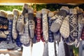 Knitted woolen mittens, lined with faux fur, hanging in a sales booth at the Christmas market, gloves for warm hands in winter,