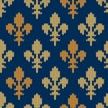 Knitted woolen pattern with heraldic golden royal lilies on blue Royalty Free Stock Photo