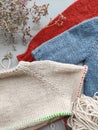 Knitter`s table with unfinished baby sweaters
